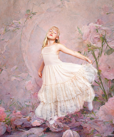 blond little girl dancing over fantasy background pink rosesの写真素材