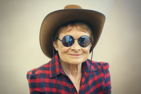 older woman wearing glasses and cowboy hatの写真素材