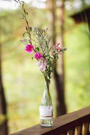forest flowers in a glass bottle stand on a derevnny window sillの写真素材