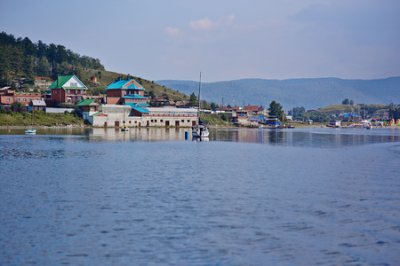 view of the coast of the lake near which there are yachts and housesの写真素材