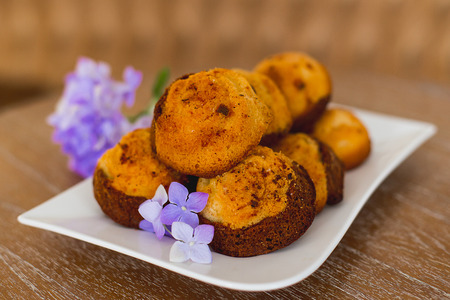 cakes on a white plate which costs on a table, lie flowers nearbyの写真素材