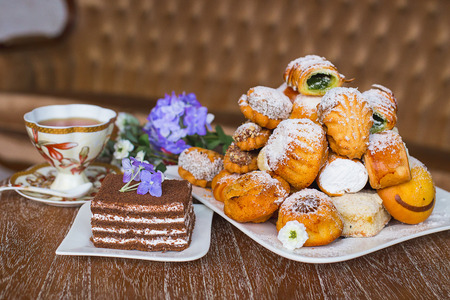 hill of confectioneryon a white plate which costs on a table, lie flowers nearbyの写真素材