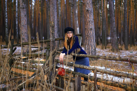 the girl wearing spectacles in a blue sweater and a trouser skirt poses in the woodの写真素材