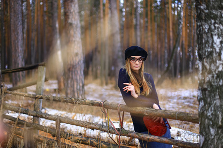 the girl wearing spectacles in a blue sweater and a trouser skirt poses in the woodの写真素材