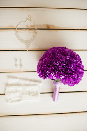 the violet bridal bouquet lies on a white timber floor nearbyの写真素材