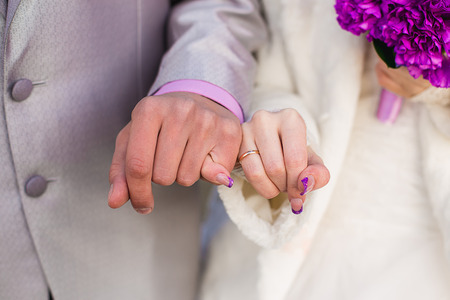 hands of the groom and the bride with wedding rings, are photographed by a close upの写真素材