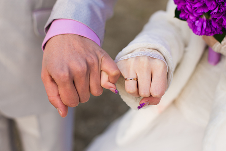 hands of the groom and the bride with wedding rings, are photographed by a close upの写真素材