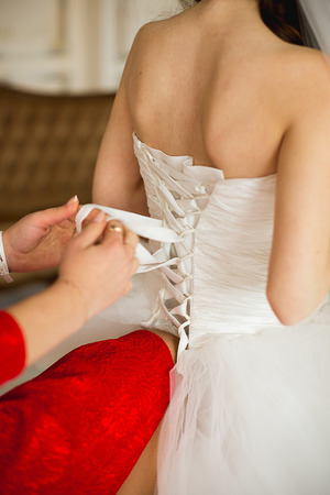 the witness ties the bride's dress on a backの写真素材