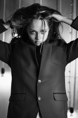 the young girl in a jacket and shorts poses on the camera is black the white photoの写真素材