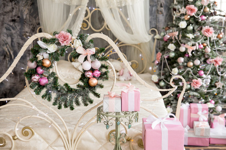 the New Year's fir-tree wreath with pink urkasheniye hangs on a bed, giftsの写真素材