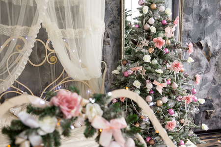 the New Year tree with pink urkasheniye costs near a bedの写真素材