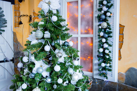 top of a Christmas fir-tree with white and silver jewelryの写真素材