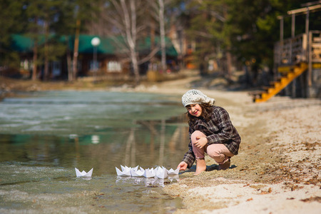 the girl in gumboots plays paper ships on the lakeの写真素材