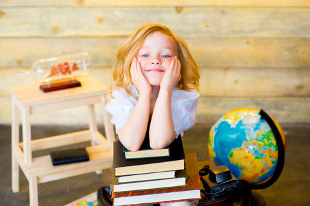 little girl posing traveler with world map, globe, books and a camera