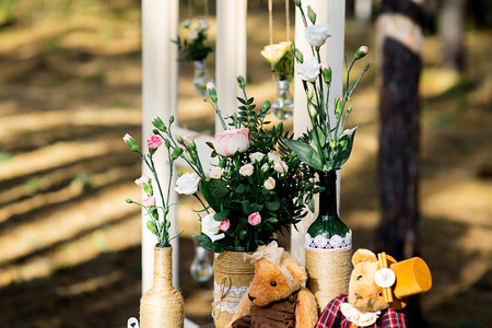 pink roses in glass bottles decorated with burlap face on old suitcase with strawの写真素材