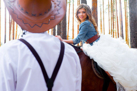 wedding, country-style glamor in the forest. ?ouple posing on a horseの写真素材