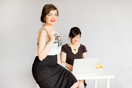 two girl in a business suit with glasses on a gray backgroundの写真素材