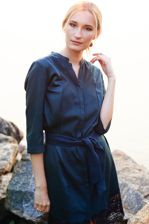 fashion blond girl in dress posing near the rockの写真素材