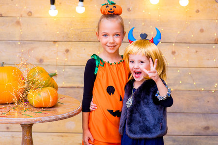 Happy group of children during Halloween party playing around the table with pumpkinsの写真素材