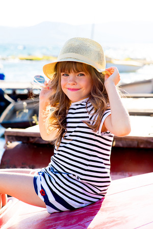 young girl with the boat, looking around and smilingの写真素材