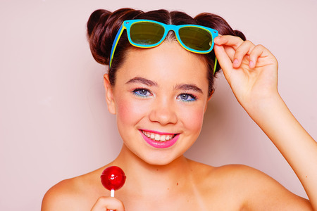 Bright skin young girl with sunglasses and lollipopの写真素材