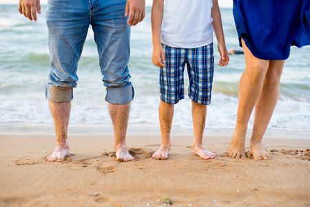 foot adults and a child on the sand near the seaの写真素材