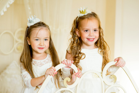 two little princess on the bed in classic dress and vintage atmosphere of the roomの写真素材