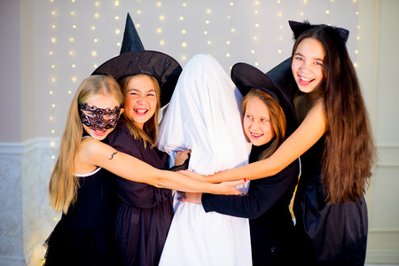 Group of teenagers wearing Halloween costumes fear of ghost, near the table with pumpkins and bottle of potion at haloween partyの写真素材