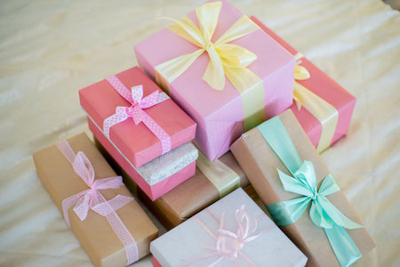 Christmas tree with gifts beside the bed, floor lamp, wrought iron chairs and table. Christmas interior in pastel colorsの写真素材