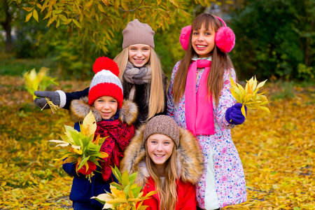 group of girls in autumn park with leafs smiling, vacation, autumn, outdoors
