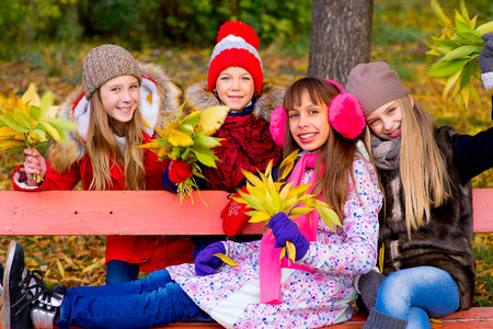 group of girls in autumn park with leafs smiling, vacation, autumn, outdoorsの写真素材
