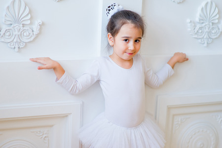 Young ballet dancer stands near white wall and smileの写真素材