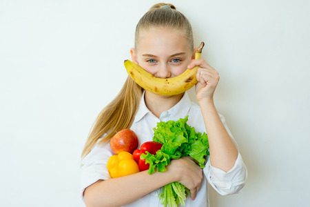 Happy fitness girl holding vegetables isolatedの写真素材