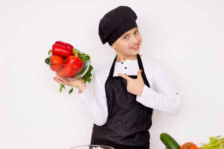 young boy holding a plate with vegetables isolateの写真素材