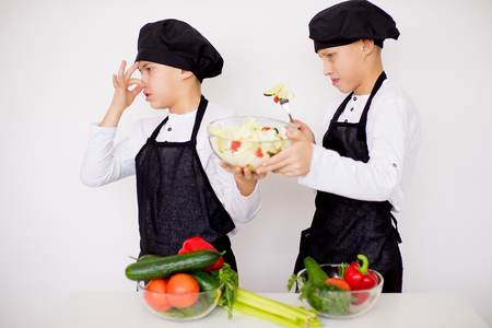 two young chefs evaluate a salad isolatedの写真素材