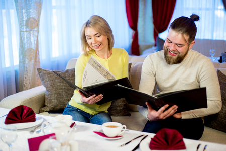 couple reading a menu in a restaurantの写真素材