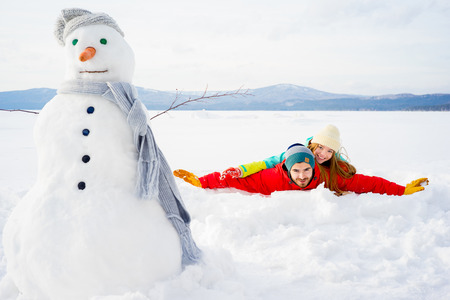 Happy couple lying in snowの写真素材