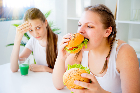 Two girls one is slim and healthy other is fatの写真素材