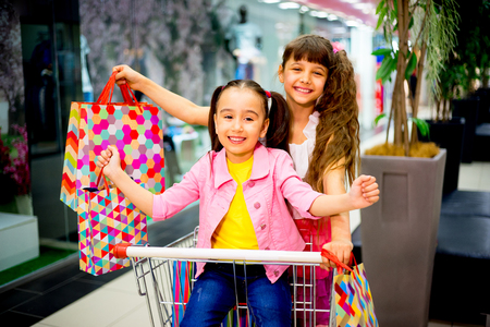 Kids in shopping cartの写真素材