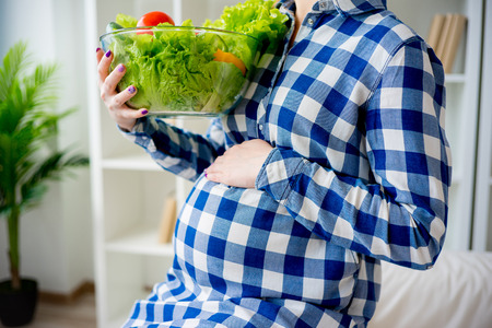 Pregnant woman eating fruitの写真素材