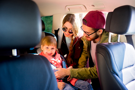 Parents adjusting baby seatの写真素材