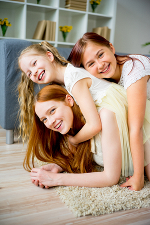 Mother and two daughters fooling aroundの写真素材