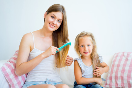 Mother and daughter taking care of hairの写真素材