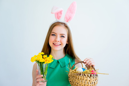 Girl with bunny ears and colored eggsの写真素材