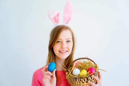 Girl with bunny ears and colored eggsの写真素材