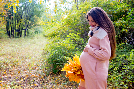Pregnant woman walking in a parkの写真素材
