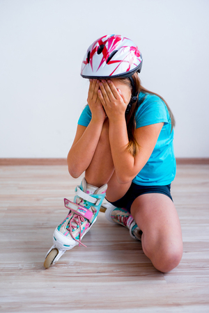 Girl fell on roller skatesの写真素材