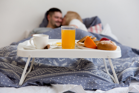 Couple enjoying breakfast in bedの写真素材