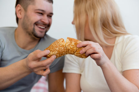 Couple enjoying breakfast in bedの写真素材