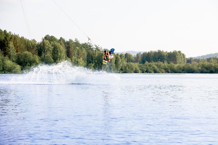 Young man riding wakeboard on a lakeの写真素材